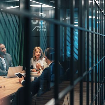 Business team engaged in a meeting inside a modern office meeting room.