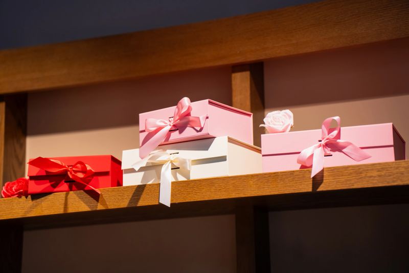Collection of luxury gift packaging with silk ribbons and decorative floral accents in a boutique shop, perfect for Valentines Day, weddings, or anniversary surprises
