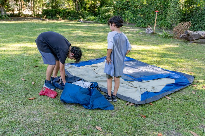 Two brothers collaborating on a camping task