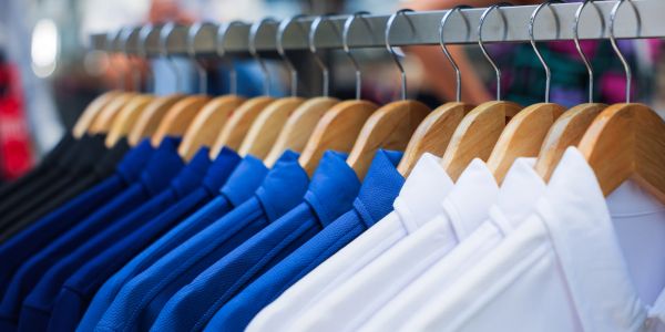 Blue and white shirts neatly hung on hangers.