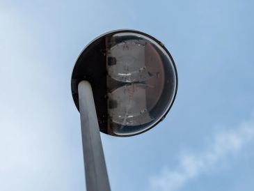 Close-up of a street lamp against a clear blue sky.