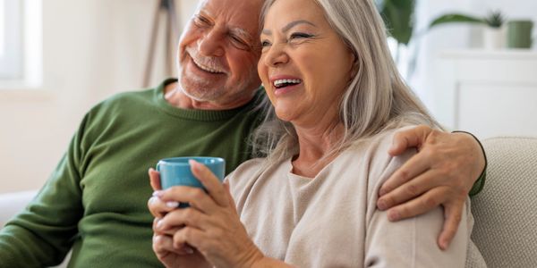 Happy elderly couple enjoying a cozy moment with a cup of coffee.