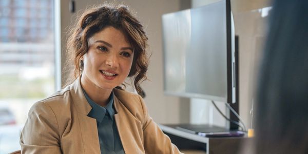 A woman in a business setting smiling.