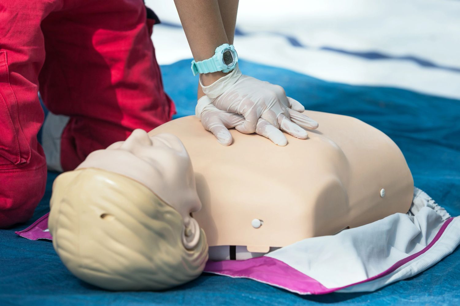 Person practicing CPR on a training mannequin.