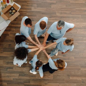 Group of volunteers joining hands in a circle.