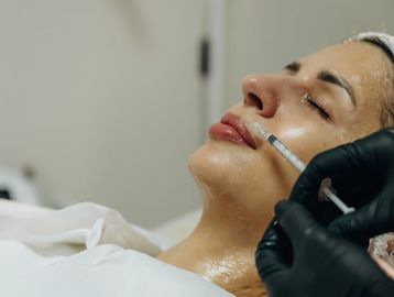 A woman receiving a cosmetic injection in her face.