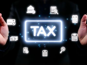 Glowing tax-related icons surrounding the word TAX on a dark background.