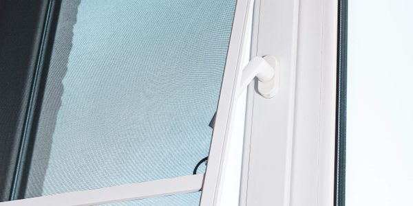 Close-up of a window with a white frame and handle.