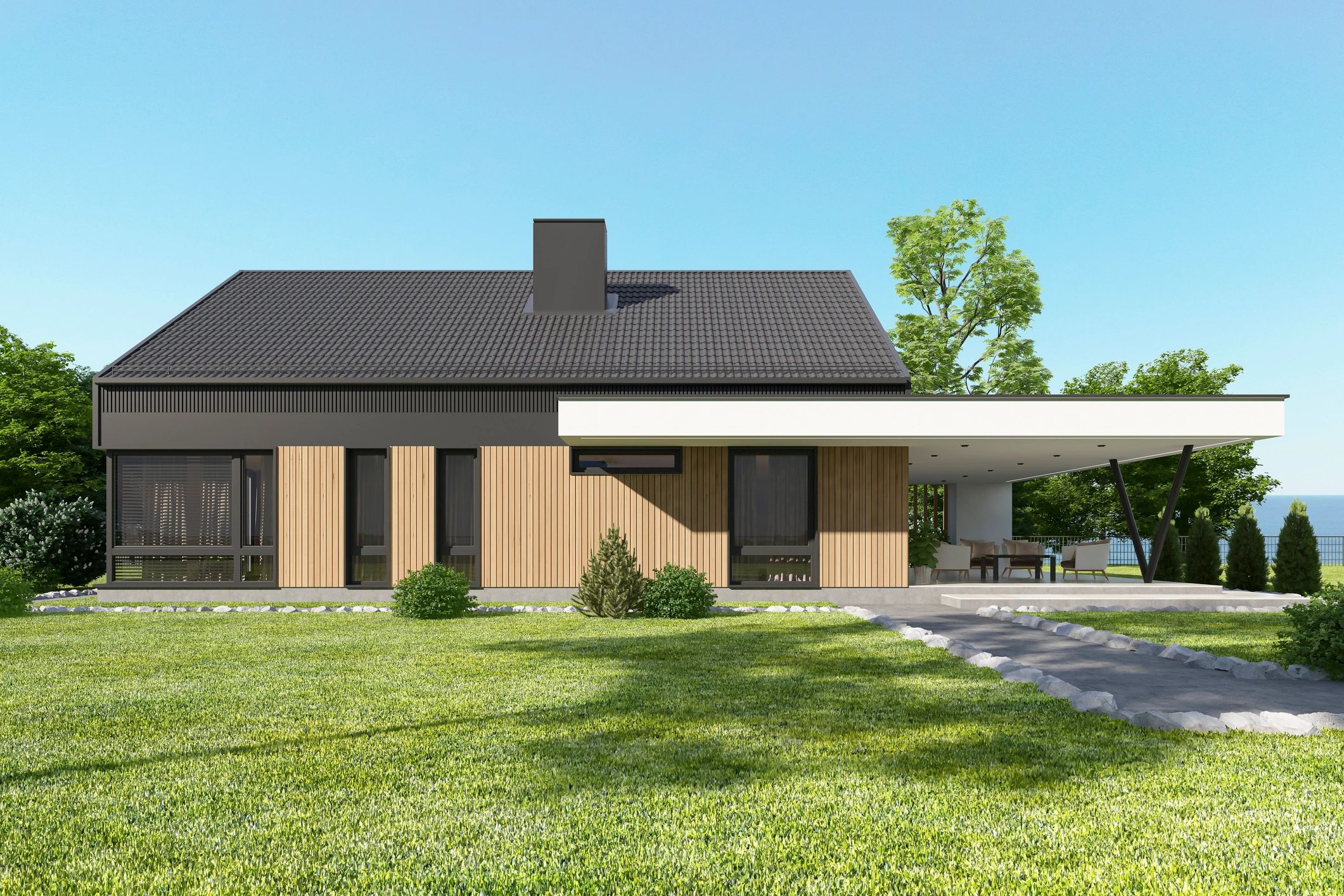 Modern house with wooden facade and large patio under clear blue sky.
