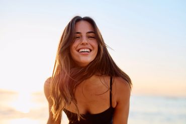 Smiling woman enjoying a sunny day at the beach.