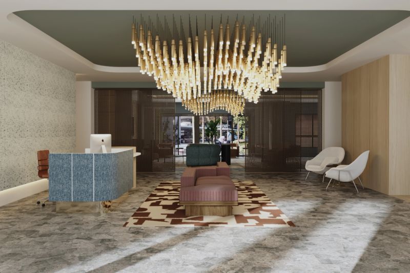 A contemporary hotel lobby featuring a striking chandelier made of wooden elements. The space includes a reception desk, comfortable seating, and a patterned rug, creating an inviting atmosphere for guests.