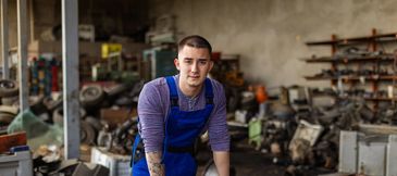 Mechanic working in a cluttered workshop.