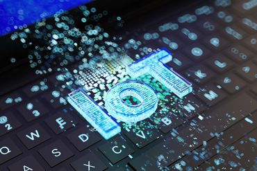 Futuristic IoT digital interface glowing over a laptop keyboard.