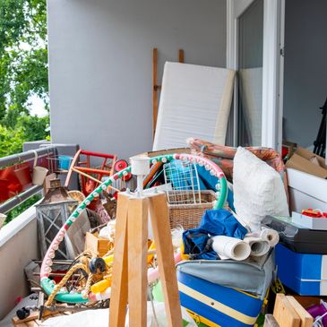 Cluttered balcony with various household items and toys.
