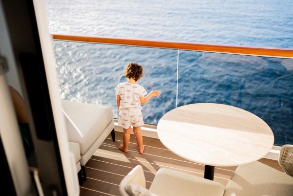 Child on a balcony overlooking the ocean.