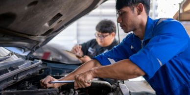 Two mechanics working on a car engine.