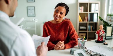 Patient consulting doctor in clinic.
