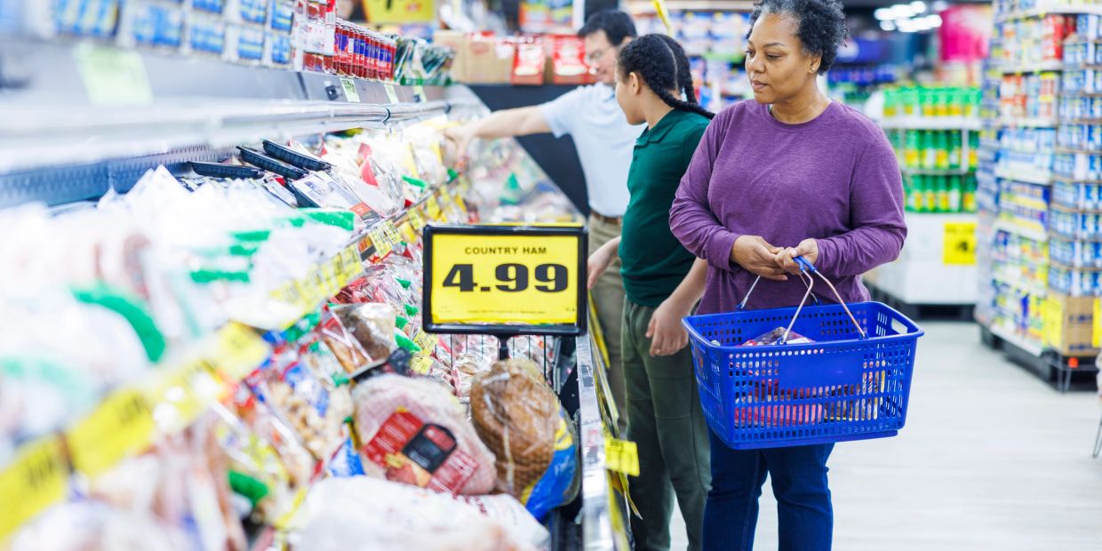 People shopping in a grocery store aisle.