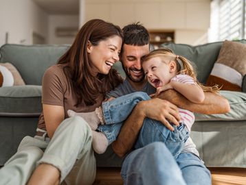 Happy family playing together on the floor.