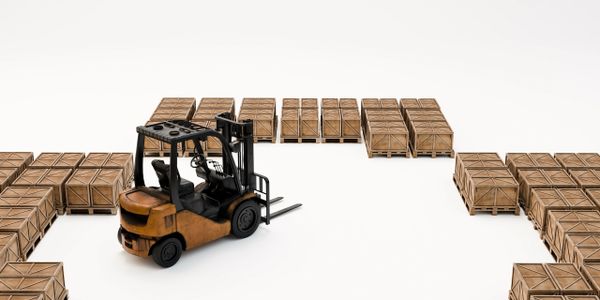 A forklift surrounded by wooden crates on pallets in a white space.