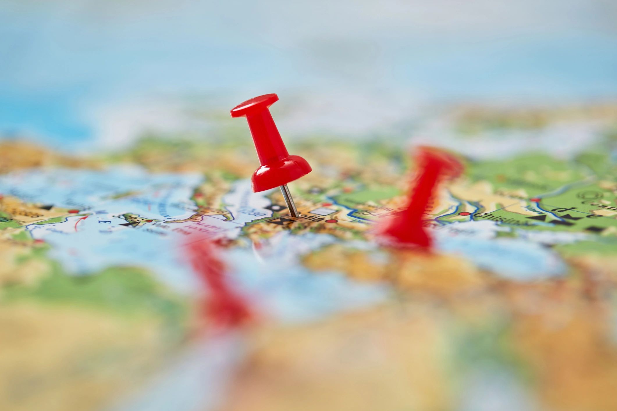 Red push pins on a map for marking locations.