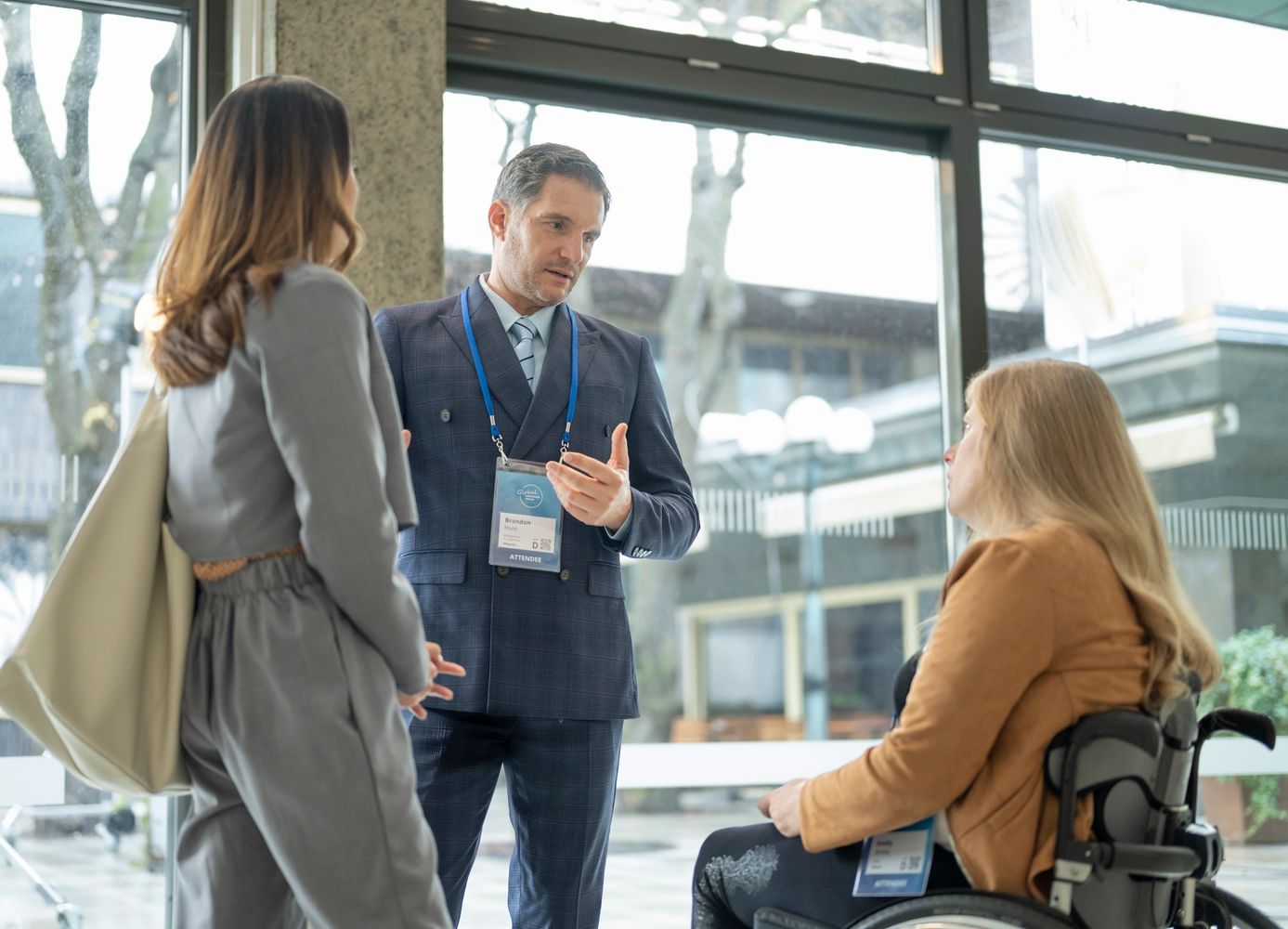 A woman and man talking to a woman in a wheelchair. 