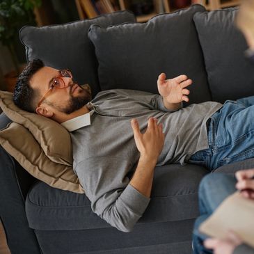 Man lying on a couch talking.