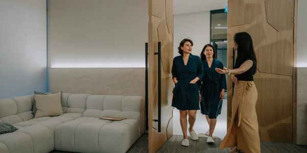 Three women entering a modern living room.
