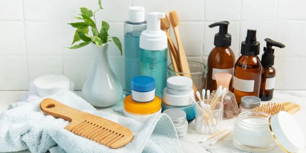 Wooden comb and skincare bottles on bathroom counter.