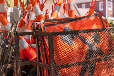 Stack of orange traffic cones and warning signs.