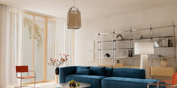 Modern living room with blue sectional sofa and tall windows.