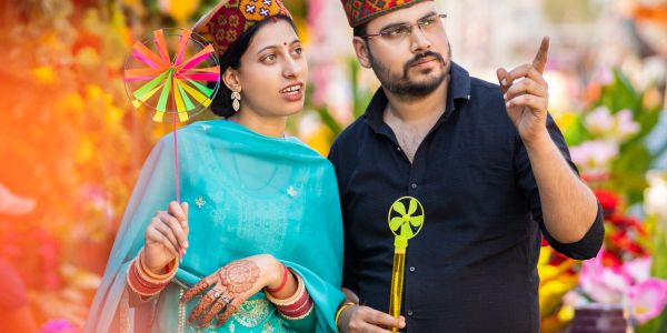Couple in traditional attire with colorful pinwheels.