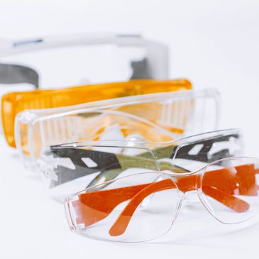 Stack of various colored safety glasses arranged in a row.