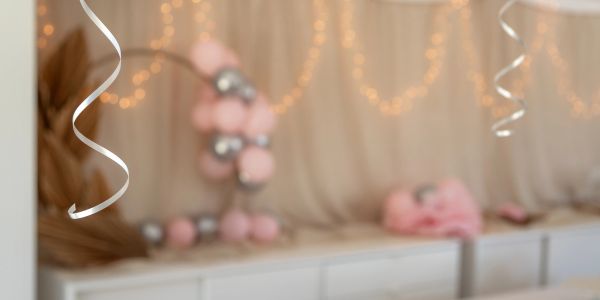 Indoor celebration setup with balloons and fairy lights.