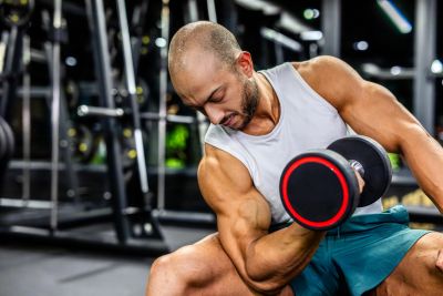 Man lifting dumbbell in gym.