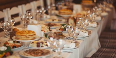 A long dining table set with plates, glasses, and various dishes for a meal.