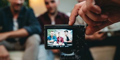 Three men posing for a photo on a digital camera.