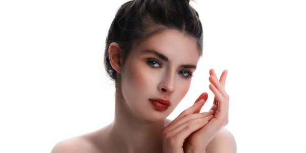 Portrait of a woman with clear skin and red lipstick.