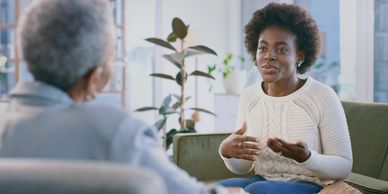 Two women having a serious conversation indoors.
