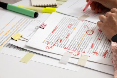 Person proofreading and marking up printed documents.