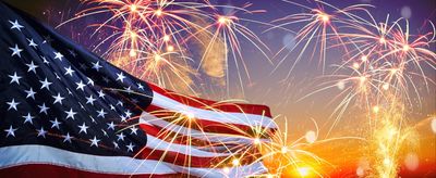 American flag with fireworks in the background.