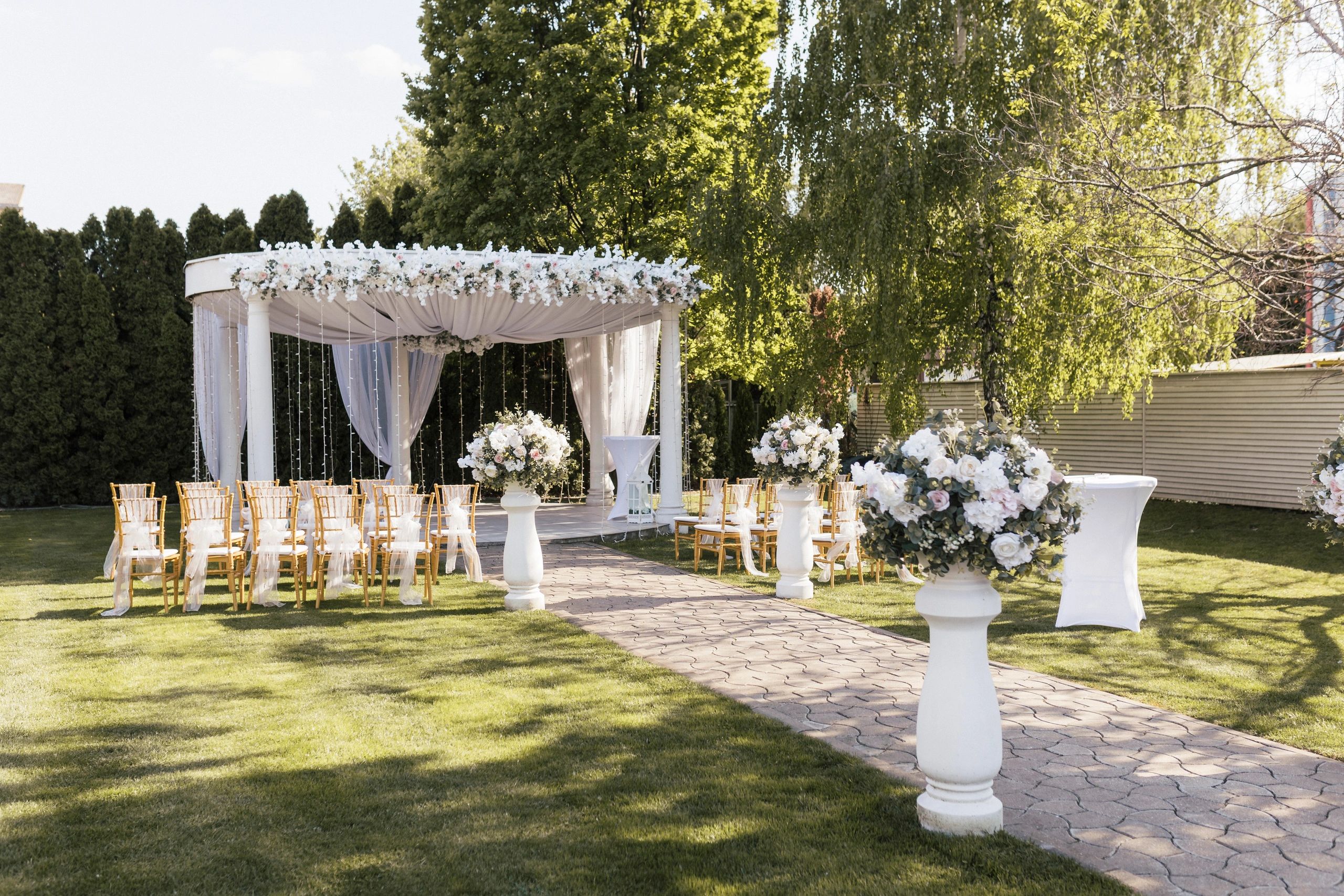 Outdoor wedding setup with floral decorations and chairs.