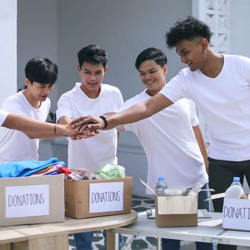 Young men volunteering with donation boxes.