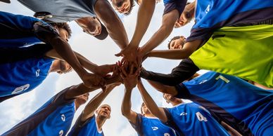 Team huddle with hands joined in the center.