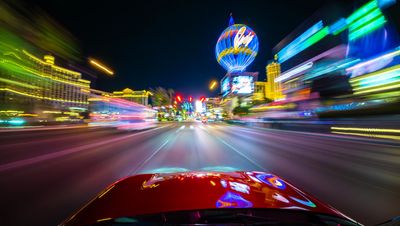 Nighttime city street with colorful light trails.