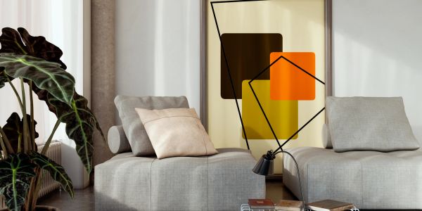 Sala moderna con sillones grises y arte abstracto en la pared.