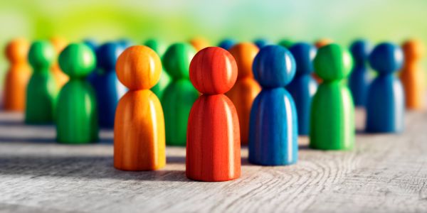Colorful wooden figures standing together on a wooden surface.