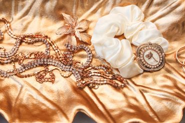 Elegant jewelry and hair accessories on shiny gold fabric.