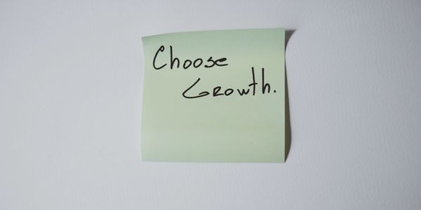 Sticky note with handwritten message: 'Choose Growth.'