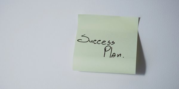 A note with 'Success Plan.' written on it.